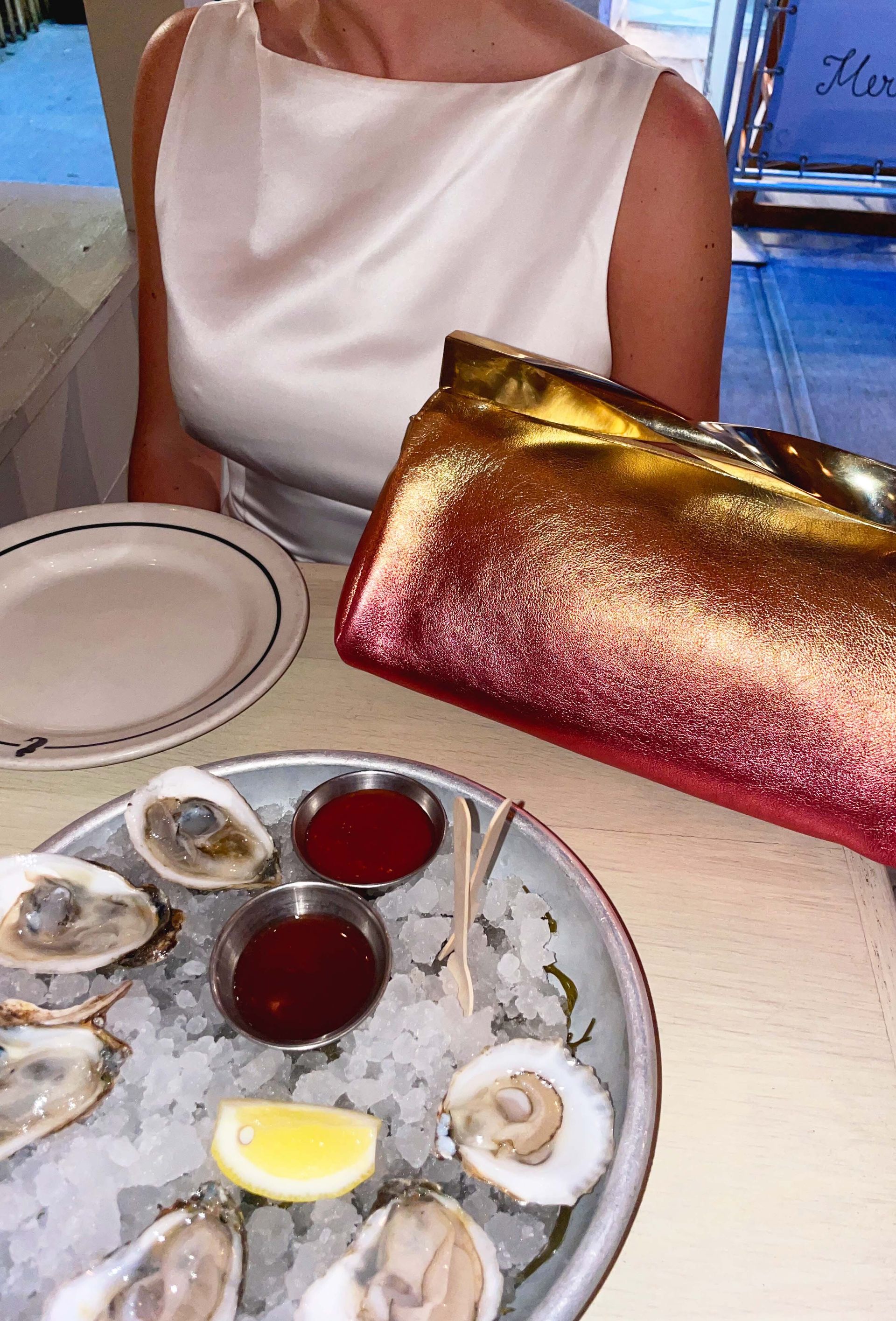 Emma Childs holding Aquazarra's Twist Clutch in Sunrise in New York City.