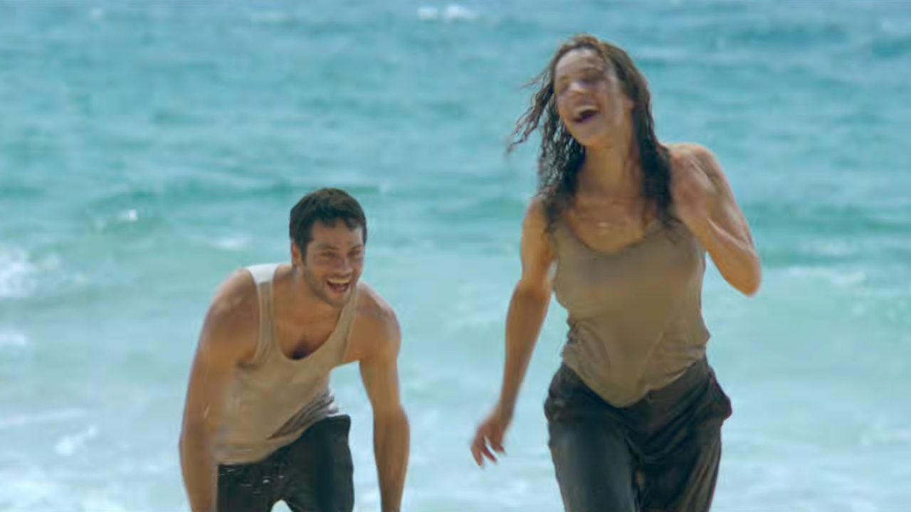 Dylan O'Brien as Bradley Preston and Rachel McAdams as Laura Liddle run on the beach in Send Help.