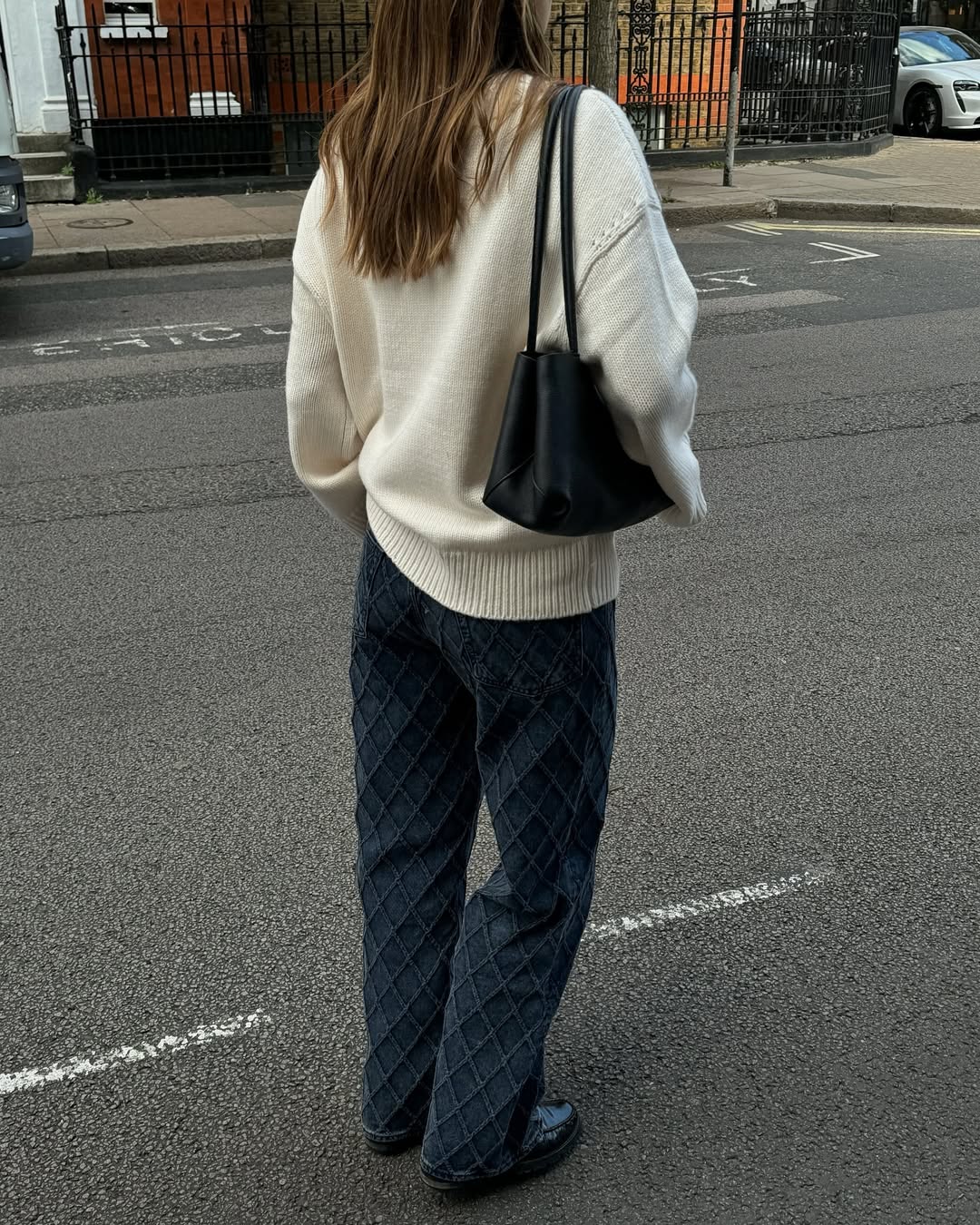 Poppy in dark wash jeans and a cream jumper.