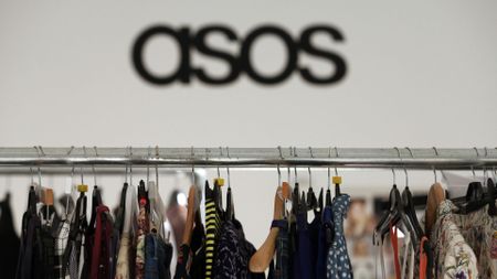 Women's clothes hang on a rail in the headquarters of Asos Plc in London, U.K