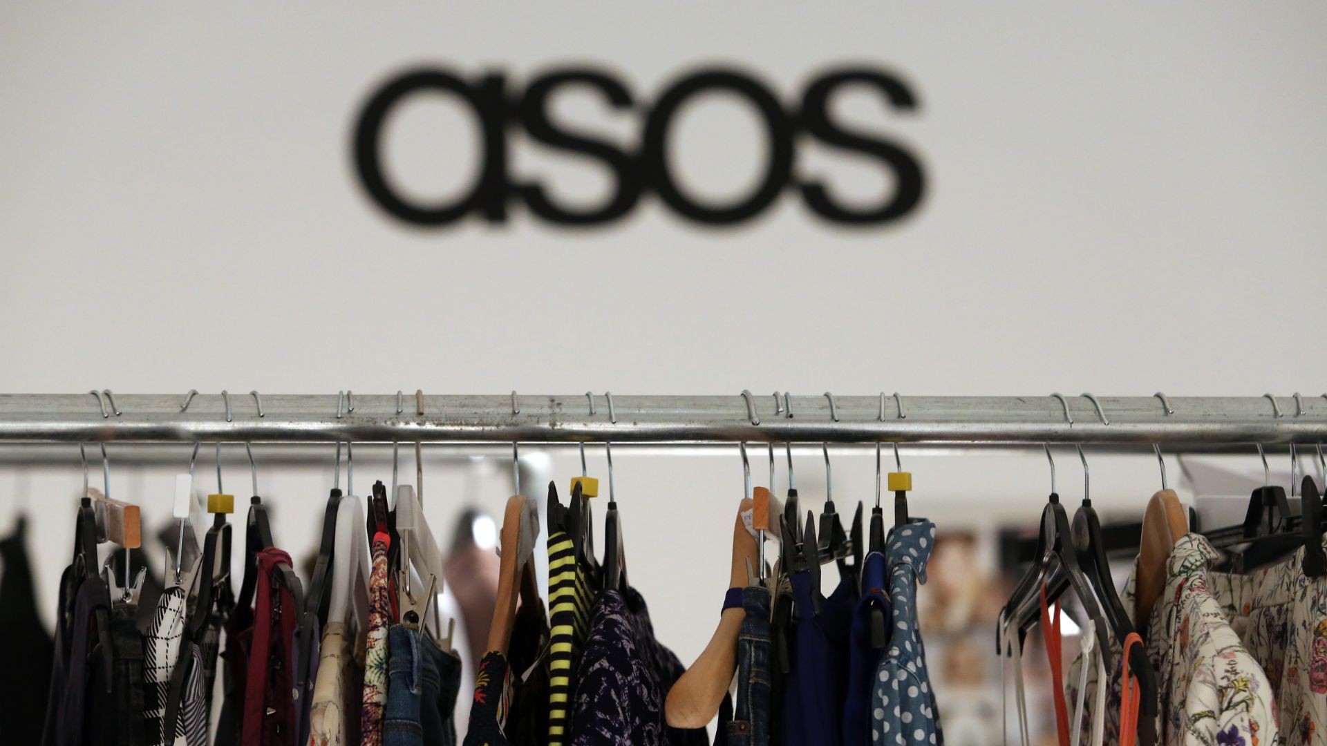 Women's clothes hang on a rail in the headquarters of Asos Plc in London, U.K