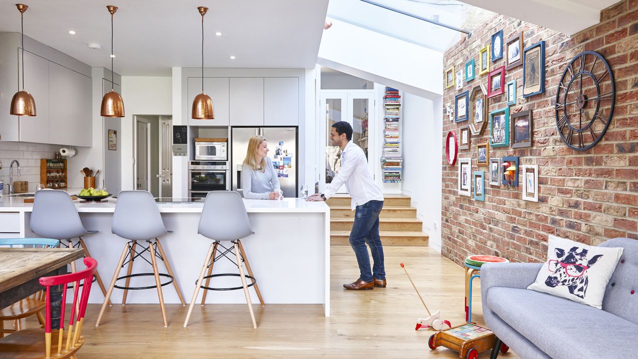 open plan kitchen diner and living area with exposed brick wall and white kitchen