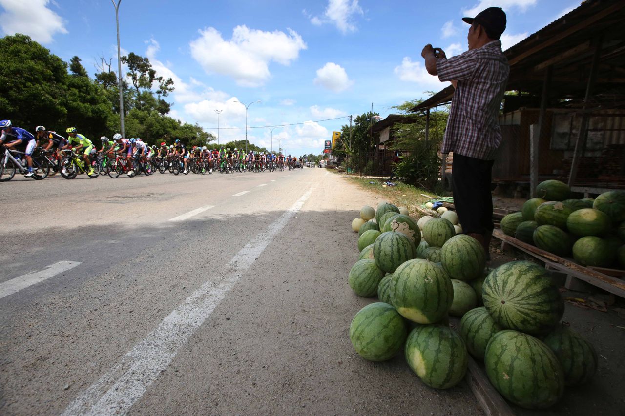 A fruit seller watches the race go by
