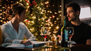 Kaitlyn Leeb and Scott Cavalheiro sit at a table drinking wine in 'Christmas With a View'