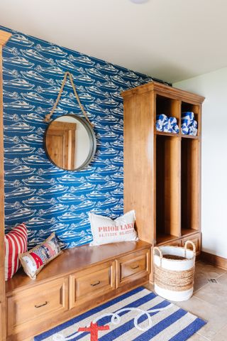 hallway boot room with nautical wallpaper and blue and white stripe rug