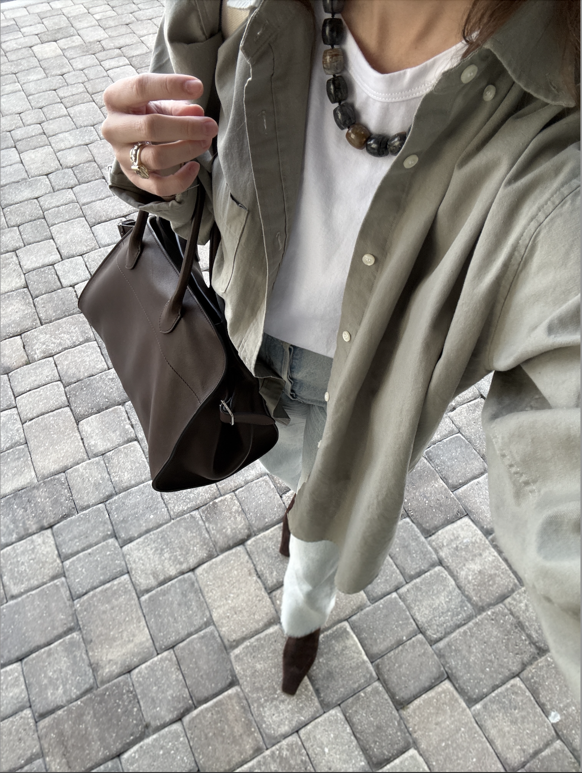 Rachel Whitehouse wears white t-shirt, green button down, and boots
