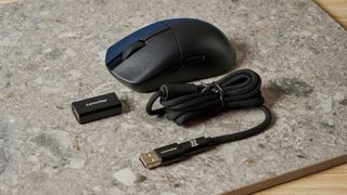 A black Lemokey G1 wireless gaming mouse sitting on a marble slab