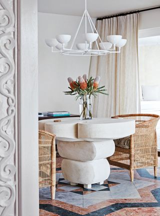 Dining room with white walls, stone floor and round table