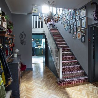 Staircase with carpets and photographs on wall