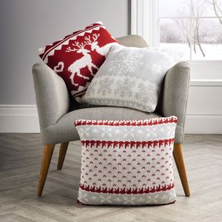 room with wooden carpet and christmas cushions on arm chair