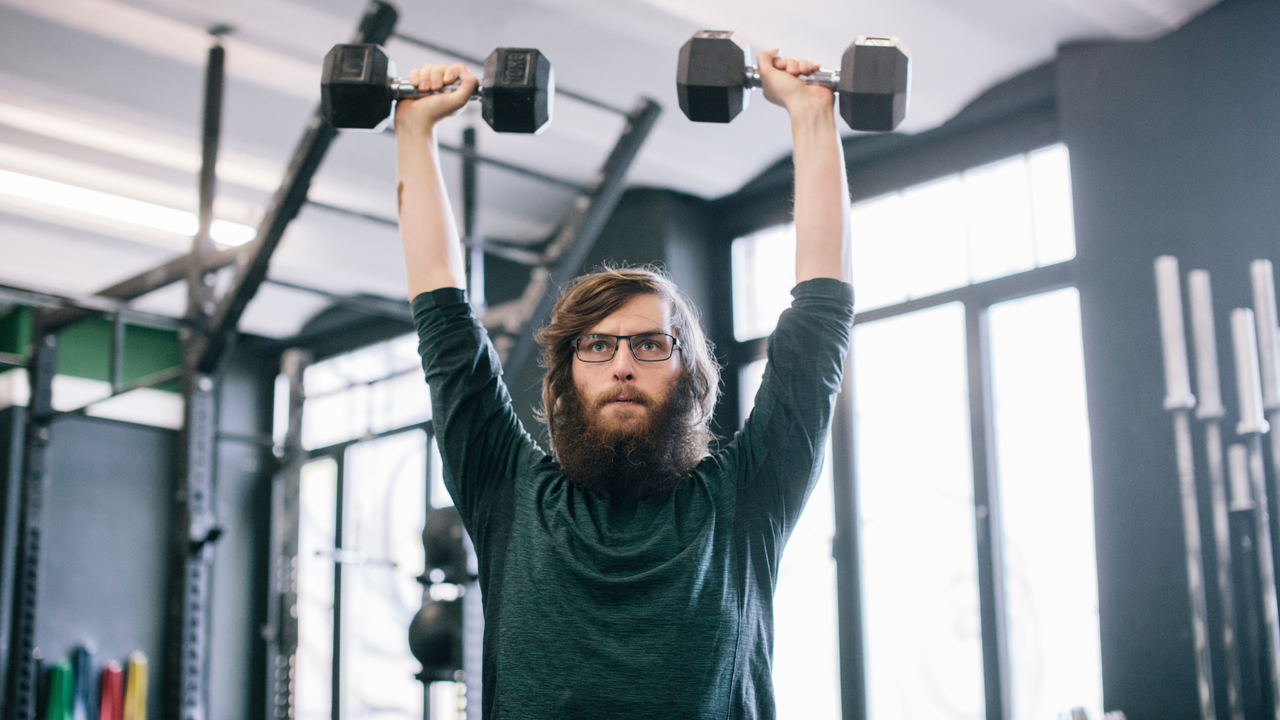 Man pressing dumbbells over his head