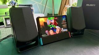 Majority DX30 Bluetooth speakers next to a Nintendo Switch OLED playing Lugi's Mansion 2 HD. 