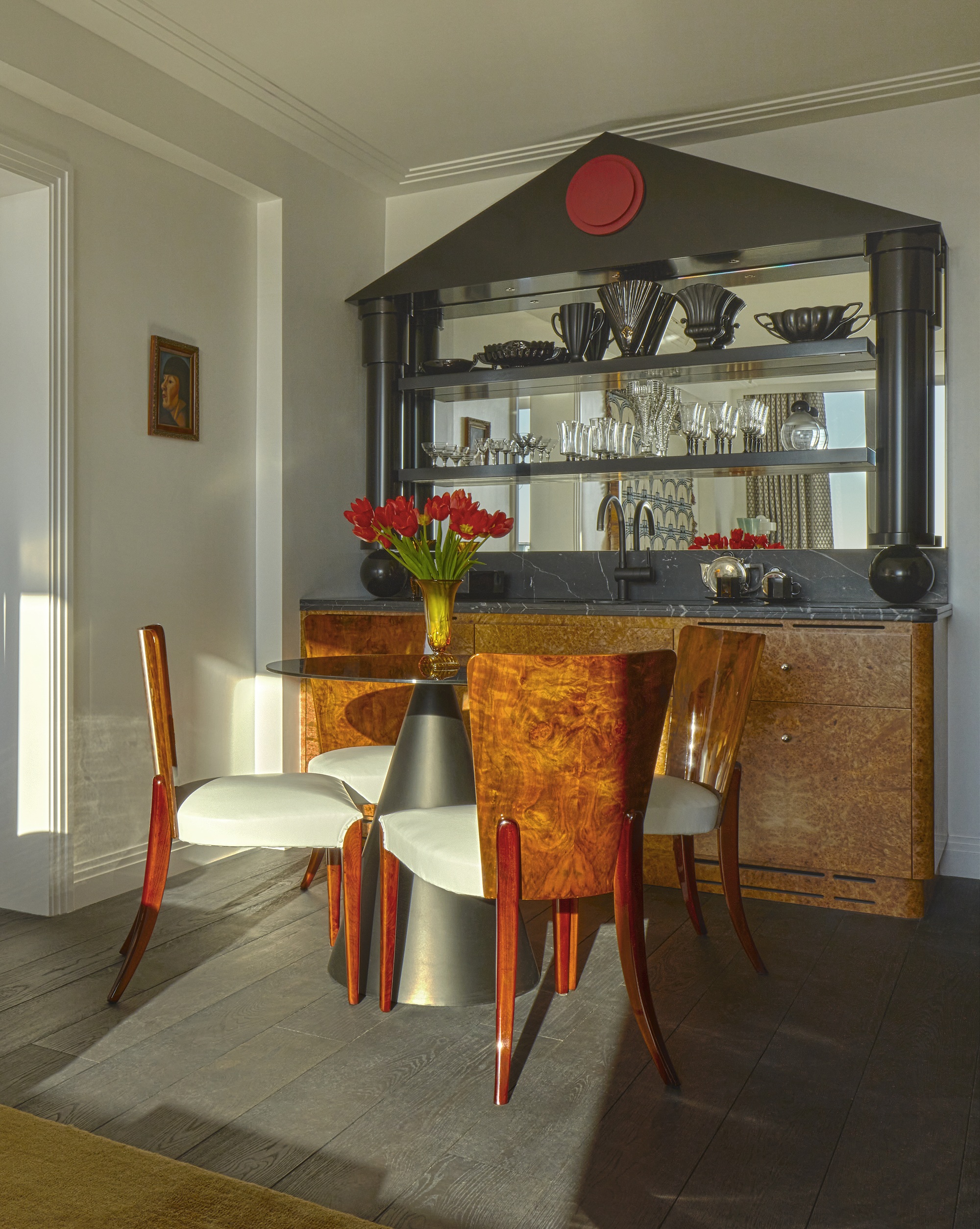 an art deco inspired bar with burl cabinets with a table in front