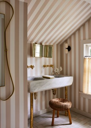 Striped wallpaper in a pale pink bathroom