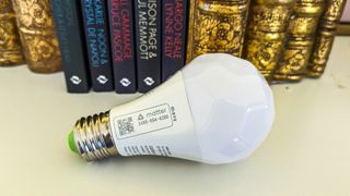Nanoleaf Essentials smart bulb on its side unplugged from lamp