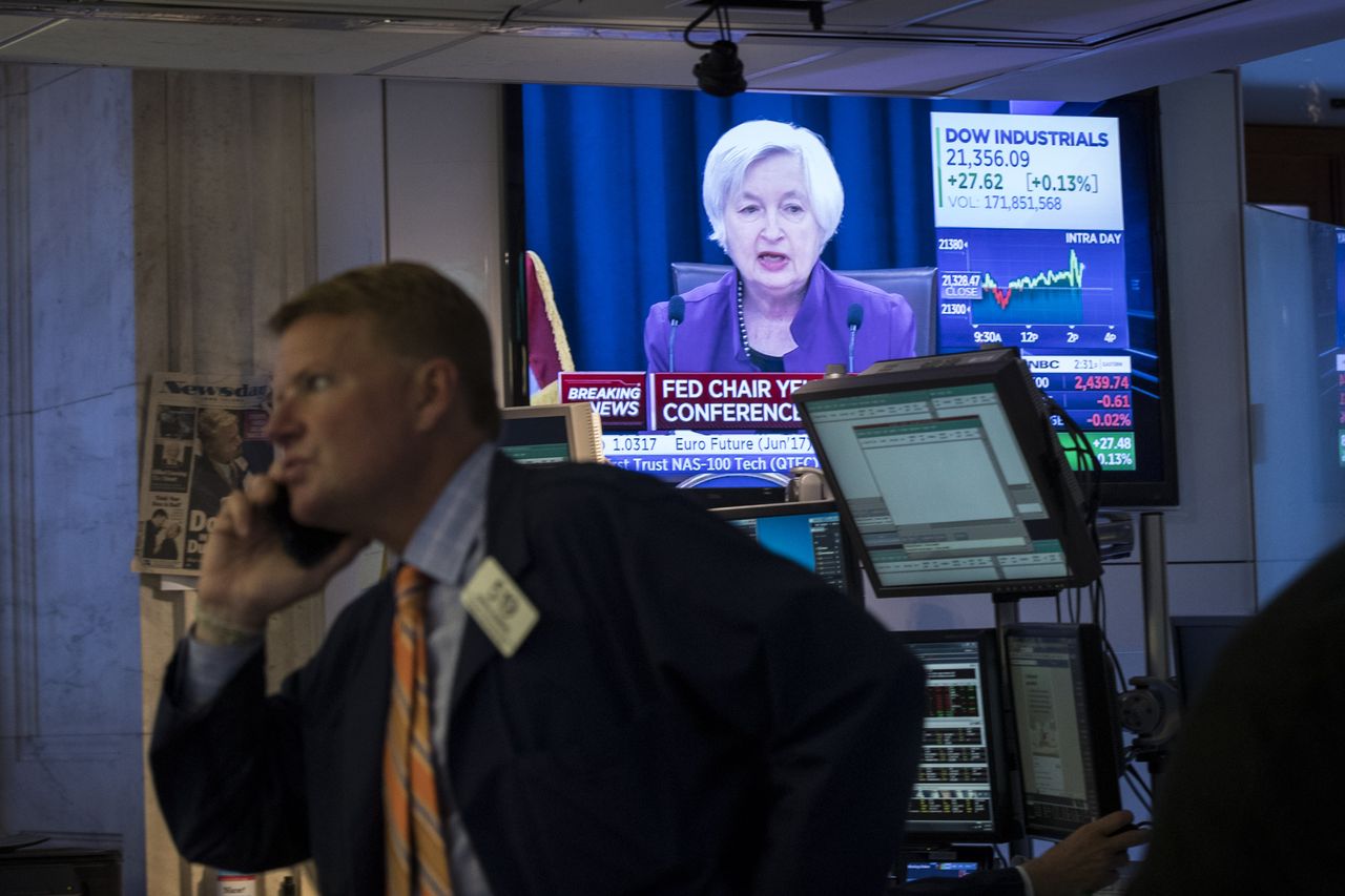 Janet Yellen on TV while traders work