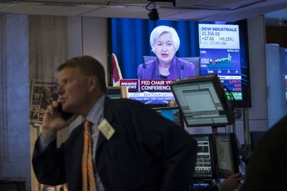 Janet Yellen on TV while traders work