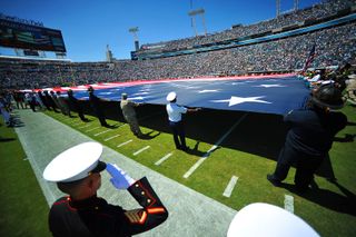 service members participate in a ceremony commemorating the 10th anniversary of the Sept. 11, 2001 terrorist attacks before a Jacksonville Jaguars NFL game.