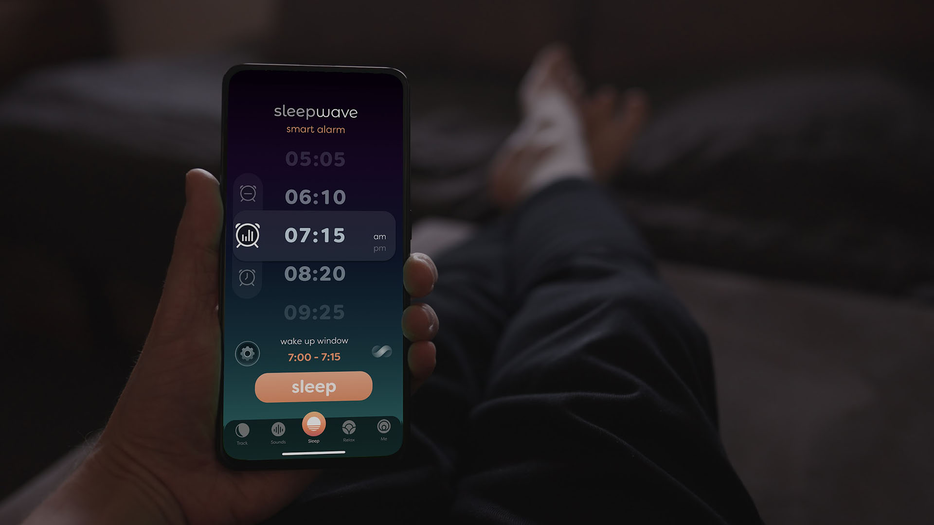 Una persona sentada en la cama, mirando la aplicación Sleepwave en su teléfono inteligente