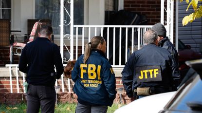Members of the FBI Joint Terrorism Task Force stand in the front yard as they search a home in Dearborn, Michigan, on October 31, 2025. FBI Director Kash Patel said Friday that the agency had thwarted a "potential terrorist attack" planned in the northern state of Michigan over Halloween weekend. Patel said the FBI arrested multiple subjects. (Photo by JEFF KOWALSKY / AFP) (Photo by JEFF KOWALSKY/AFP via Getty Images)