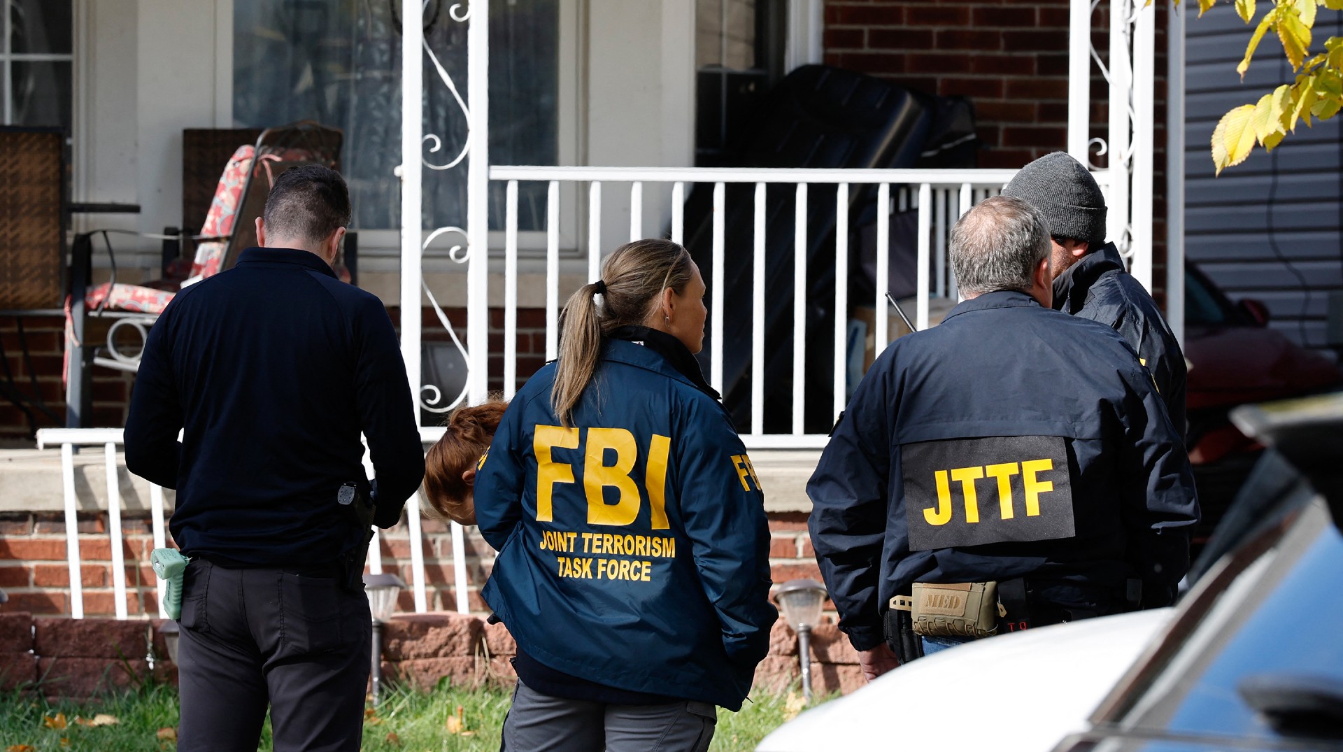 Members of the FBI Joint Terrorism Task Force stand in the front yard as they search a home in Dearborn, Michigan, on October 31, 2025. FBI Director Kash Patel said Friday that the agency had thwarted a "potential terrorist attack" planned in the northern state of Michigan over Halloween weekend. Patel said the FBI arrested multiple subjects. (Photo by JEFF KOWALSKY / AFP) (Photo by JEFF KOWALSKY/AFP via Getty Images)