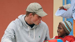 Prince Harry pulling faces with a child