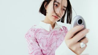 The Kyu camera held in a person's hand