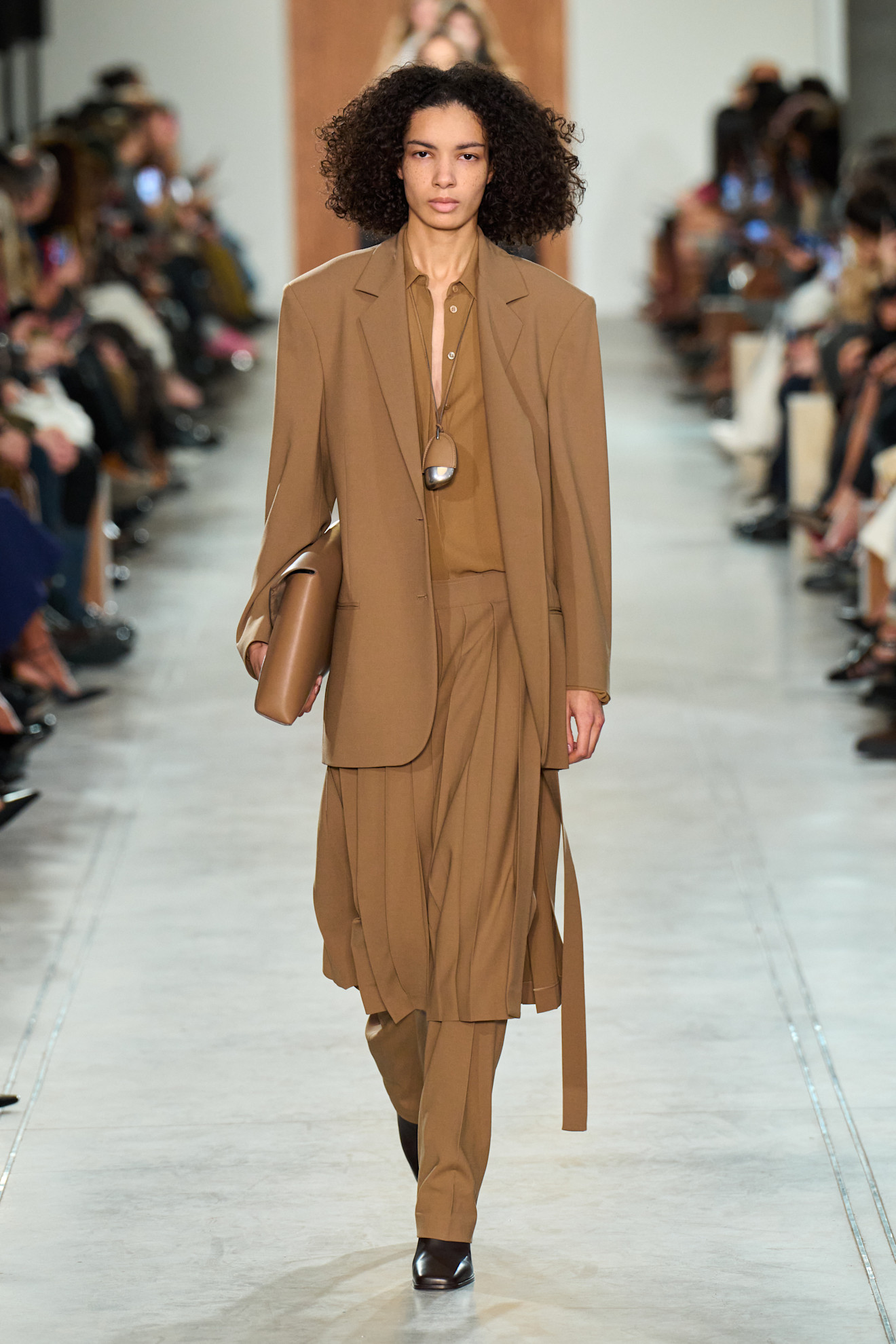 A model wore skirt over pants on the Michael Kors Fall 2025 runway.