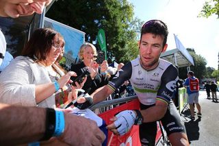 Mark Cavendish signs an autograph before the start of stage 5 in Britain.