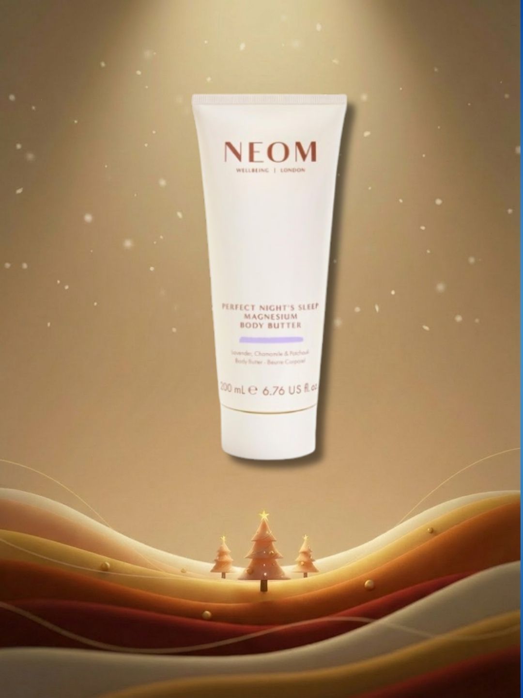 Tube of NEOM magnesium body butter on brown graphic background with gradient waves at bottom, three mini Christmas tress and stars