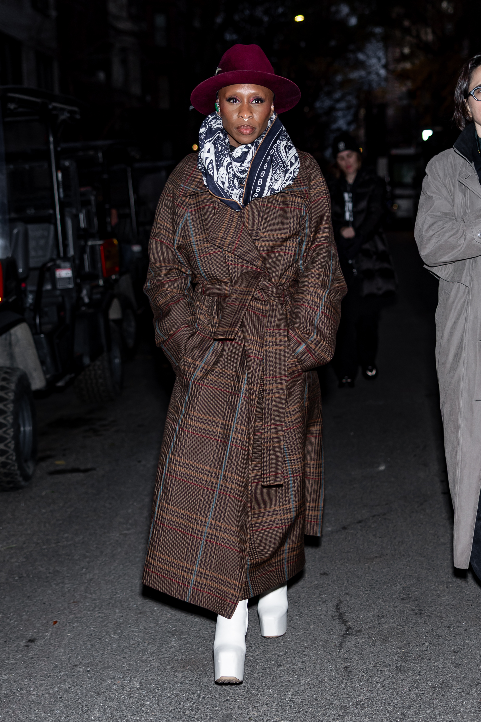Cynthia Erivo wearing a trench coat and white boots