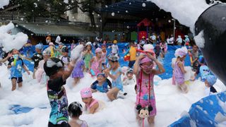 children in China frolic in soapy water at outdoor waterpark