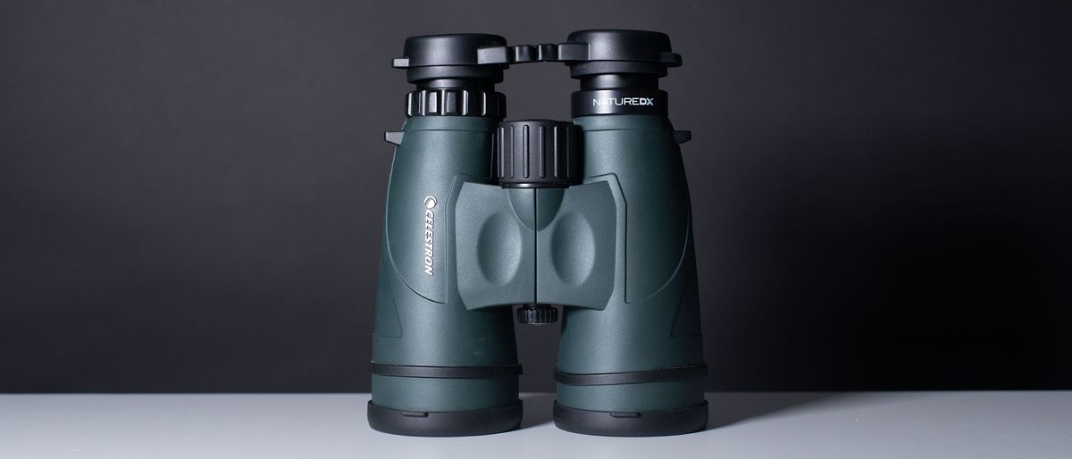 A full view of the binoculars on a white table and black backdrop