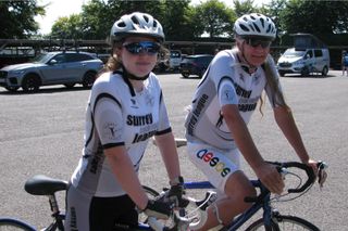 Amy Richards (izquierda) y Glyn Durrent (derecha) en sus bicicletas sonriendo a la cámara