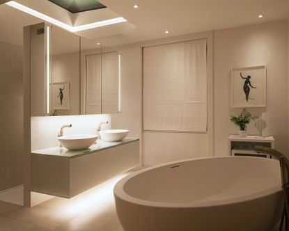 An example of bathroom lighting trends showing a white bathroom with lighting above a double vanity unit