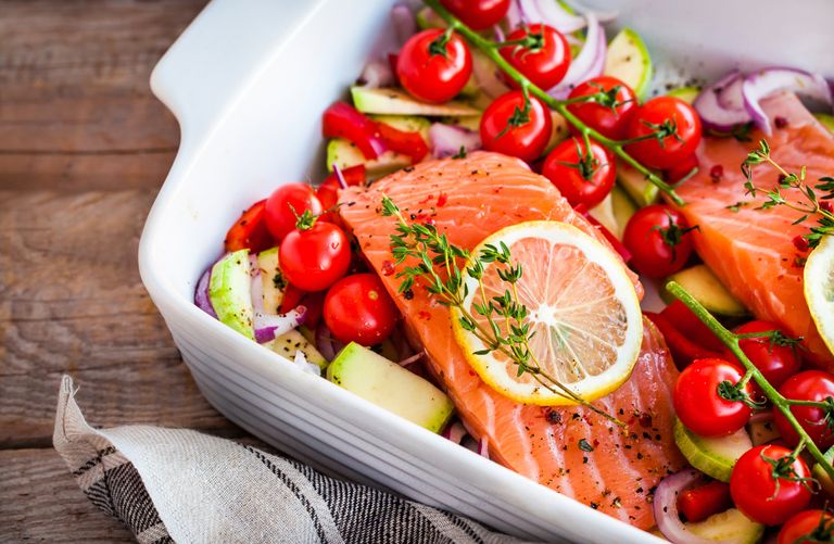 Best meal prep delivery services - Raw fresh delicious salmon, cherry tomatoes, onion, zucchini, pepper and lemon in pan, ready to cook