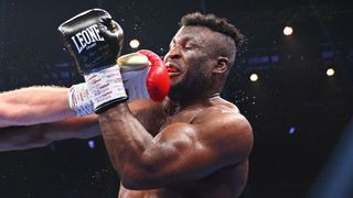 Francis Ngannou takes a punch in the ring ahead of the start of the Joshua vs Ngannou live stream in Riyadh, Saudi Arabia