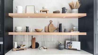 Open pine shelving in modern kitchen space with accessories and tableware