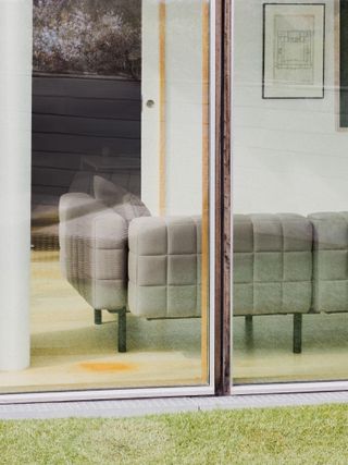 Grey sofa pictured through large window