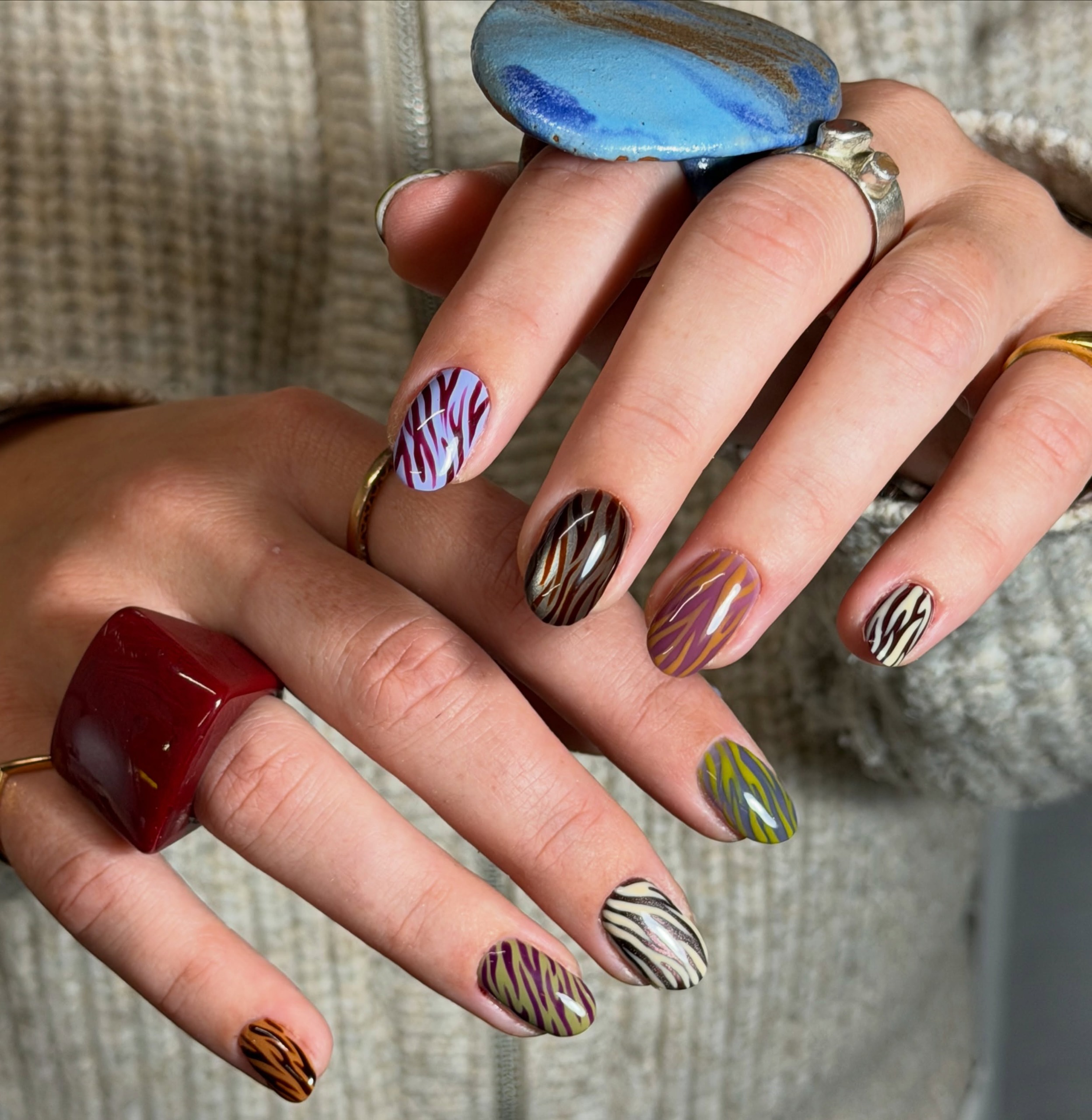 different colored zebra print nails in burgundy olive green pink brown and cream