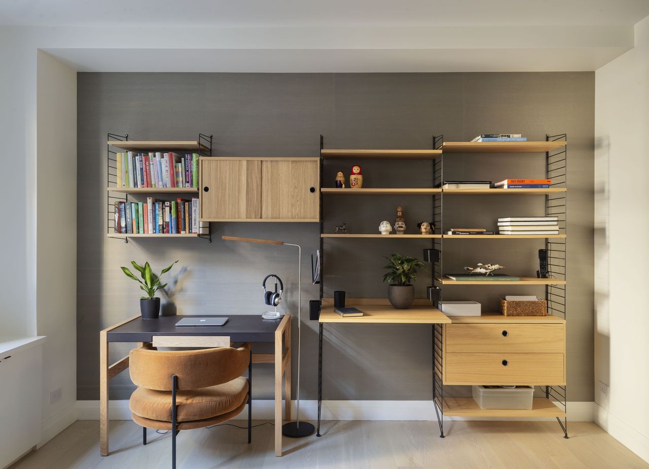 A home office with a tall standing lamp by the desk