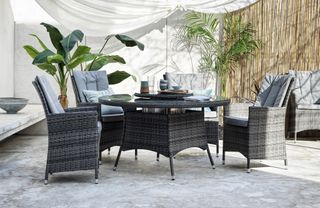 A rattan dining set with circular table and six chairs