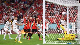 Thibaut Courtois of Belgium dives in vain as Abdelhamid Sabiri (far right) of Morocco scores their team's first goal from a free kick during the FIFA World Cup Qatar 2022 Group F match between Belgium and Morocco at Al Thumama Stadium on November 27, 2022 in Doha, Qatar.