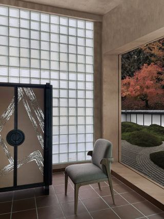 A living room space with furniture by Andre Fu, facing a traditional japanese zen garden with circular raked motifs