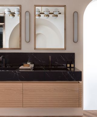 midcentury bathroom with black marble counter and double sink