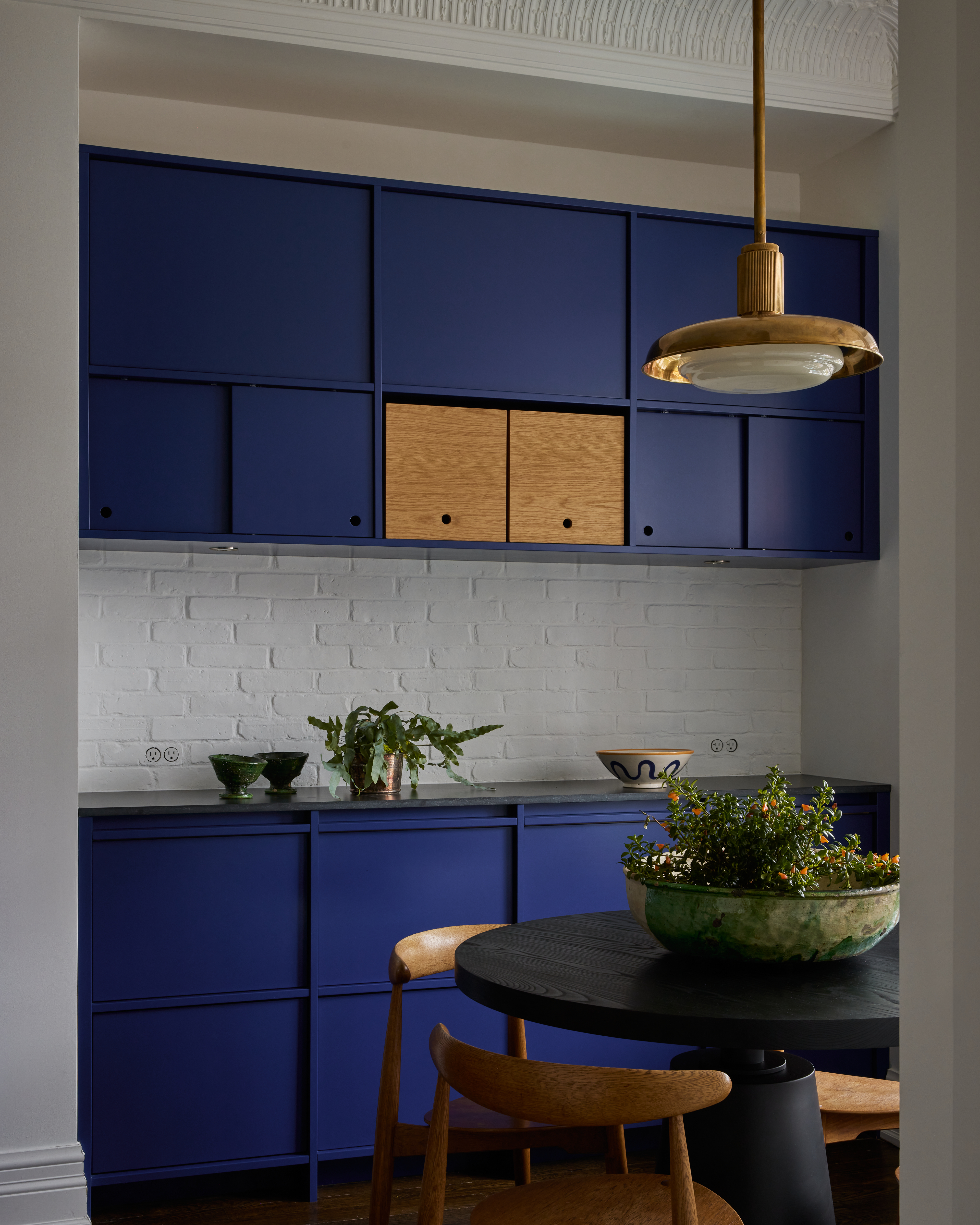 A kitchen with royal blue cabinets, and white walls