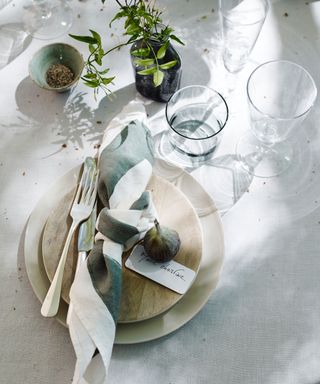 summer tabletop place setting with relaxed tied linen napkin