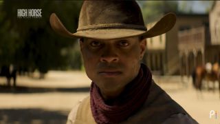An anonymous Black cowboy looks intently out towards his opponent as he prepares for a shootout in a reenactment in documentary High Horse: The Black Cowboy.