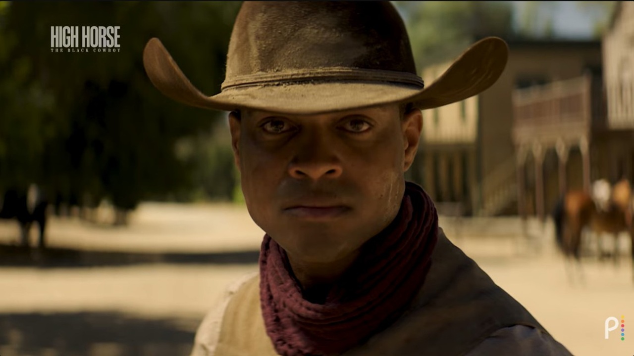 An anonymous Black cowboy looks intently out towards his opponent as he prepares for a shootout in a reenactment in documentary High Horse: The Black Cowboy.