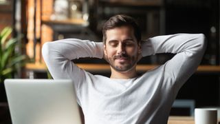 Man sitting at desk with a relaxed smile on his face